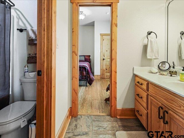 bathroom featuring toilet, vanity, and hardwood / wood-style flooring