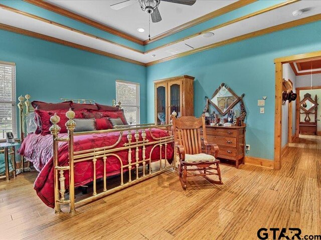 bedroom featuring hardwood / wood-style floors, multiple windows, and ornamental molding