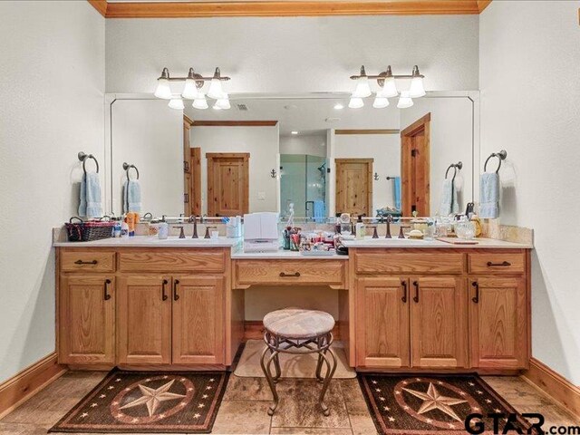 bathroom with vanity, crown molding, and a shower with door