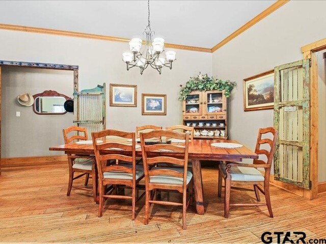 dining room featuring an inviting chandelier, light wood-type flooring, and crown molding