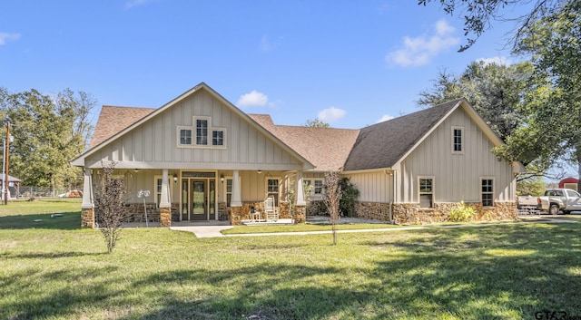 back of house with covered porch and a yard