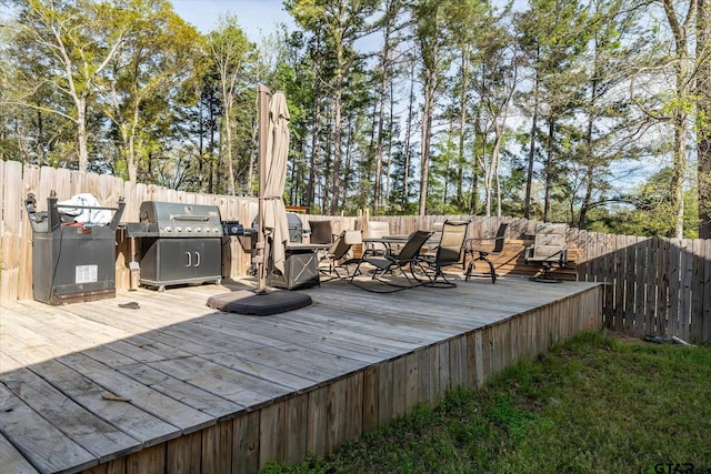 deck with a fenced backyard and area for grilling