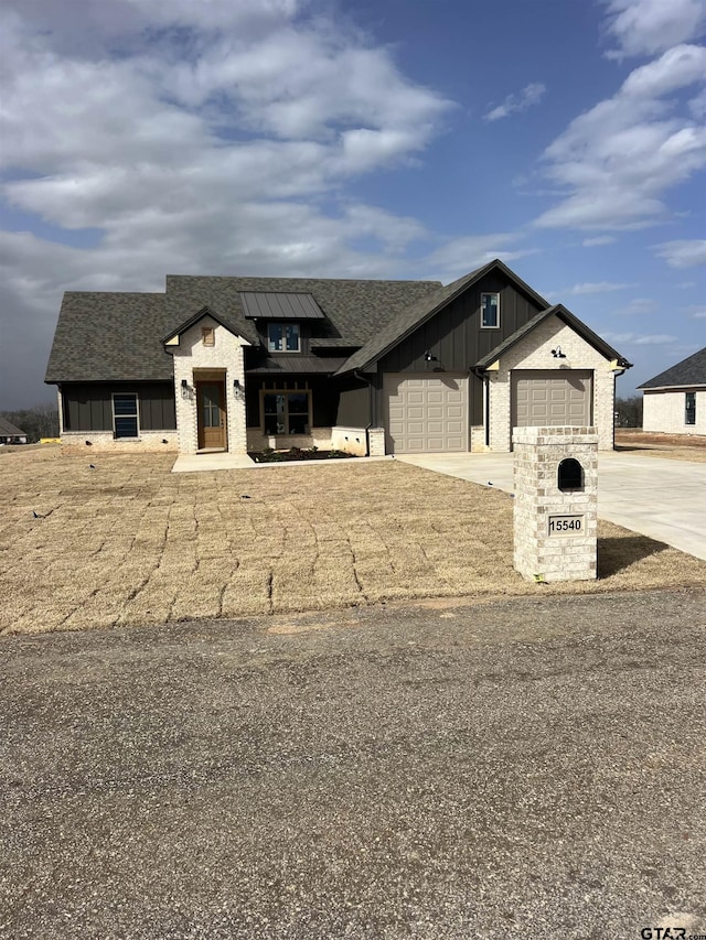 view of front facade featuring a garage, driveway, a shingled roof, and board and batten siding