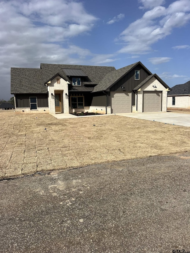 modern farmhouse with concrete driveway, a shingled roof, board and batten siding, and an attached garage