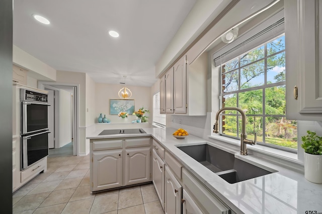 2110 Macbeth Ct, Tyler, TX 75703 - kitchen featuring a peninsula, double oven, black electric stovetop, light countertops, and a sink