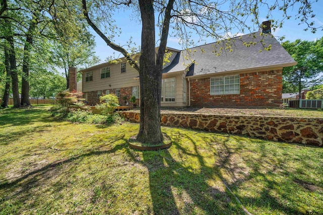 2110 Macbeth Ct, Tyler, TX 75703 - rear view of property featuring a lawn, brick siding, fence, and a chimney