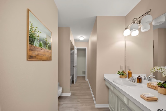 2110 Macbeth Ct, Tyler, TX 75703 - bathroom with visible vents, wood finished floors, vanity, baseboards, and toilet