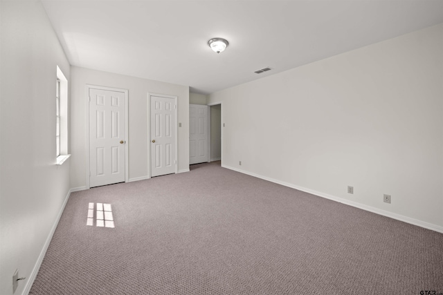 2110 Macbeth Ct, Tyler, TX 75703 - unfurnished bedroom featuring carpet floors, baseboards, visible vents, and two closets