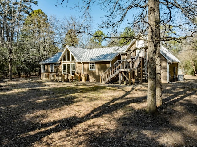 rear view of house featuring a wooden deck