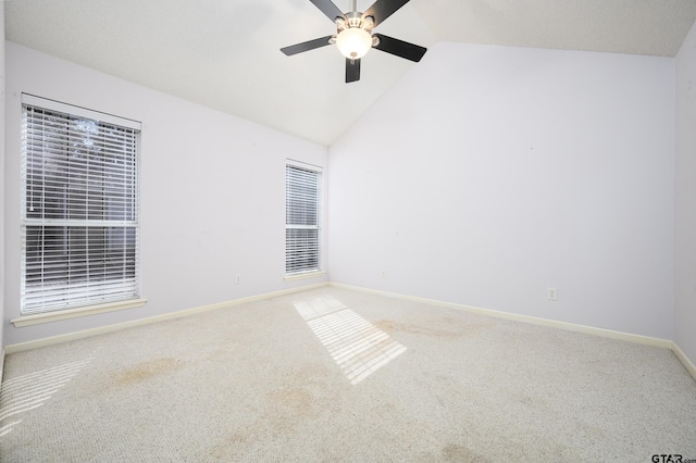 empty room with high vaulted ceiling, carpet flooring, and ceiling fan