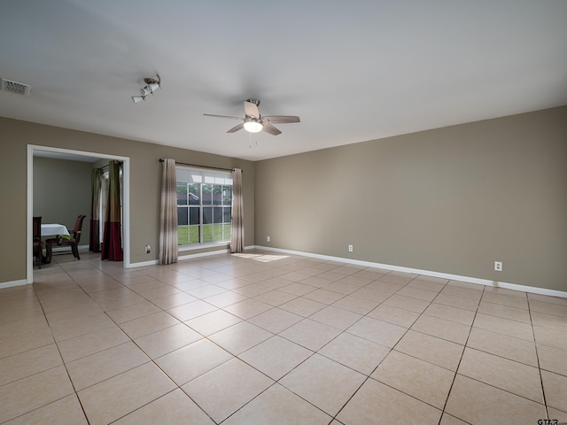 empty room featuring visible vents, ceiling fan, light tile patterned floors, and baseboards