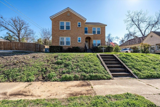 traditional-style home with brick siding and fence