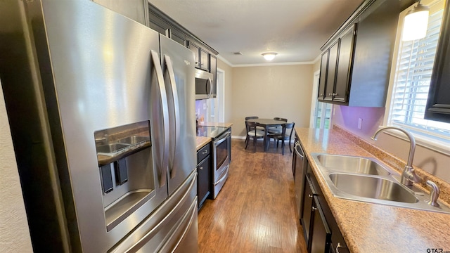 kitchen with stainless steel appliances, crown molding, sink, and dark hardwood / wood-style floors