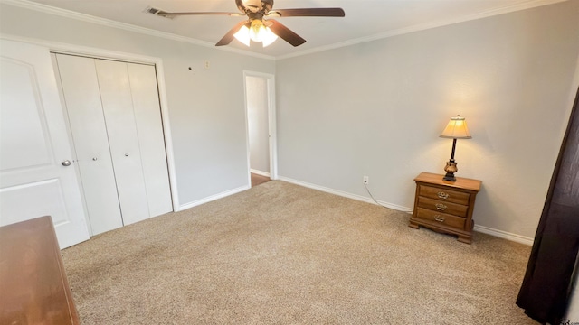 unfurnished bedroom with ceiling fan, a closet, ornamental molding, and light carpet