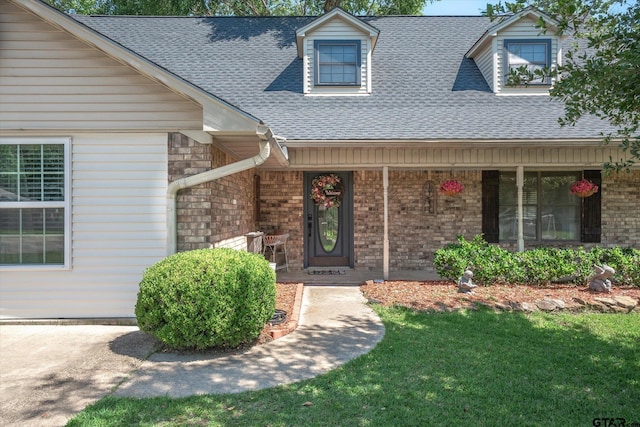 doorway to property featuring a yard and a porch