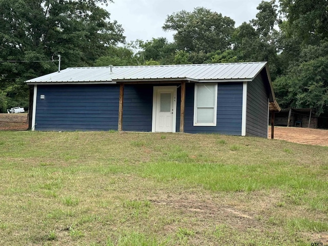 view of front of home featuring metal roof and a front lawn