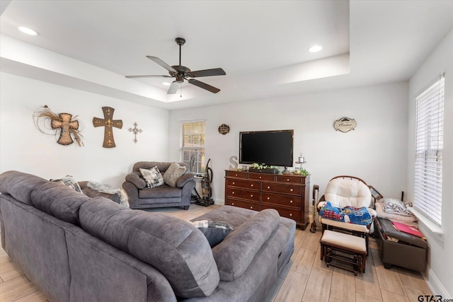 living room featuring light hardwood / wood-style floors, ceiling fan, and a healthy amount of sunlight