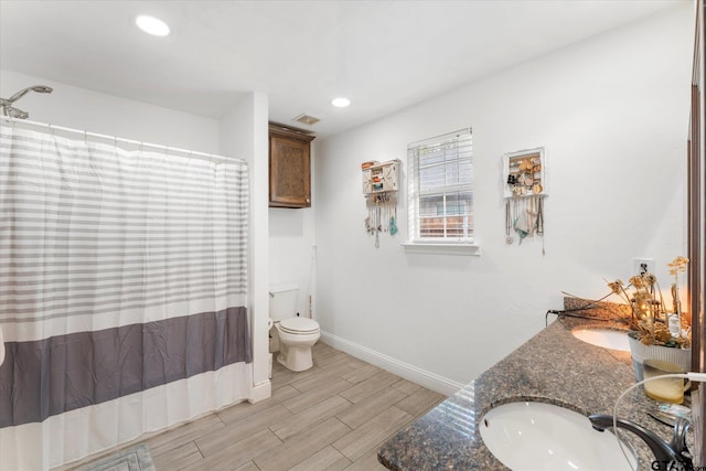 bathroom with toilet, vanity, hardwood / wood-style floors, and walk in shower