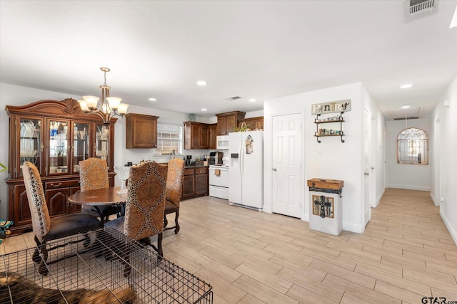 dining space with a chandelier and light hardwood / wood-style flooring