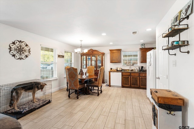 dining space featuring light hardwood / wood-style flooring and a notable chandelier