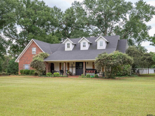 cape cod home featuring a front lawn and a porch