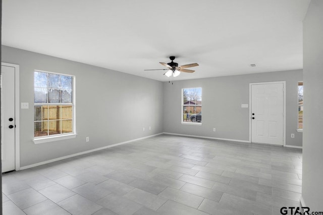 interior space featuring a healthy amount of sunlight, ceiling fan, and baseboards