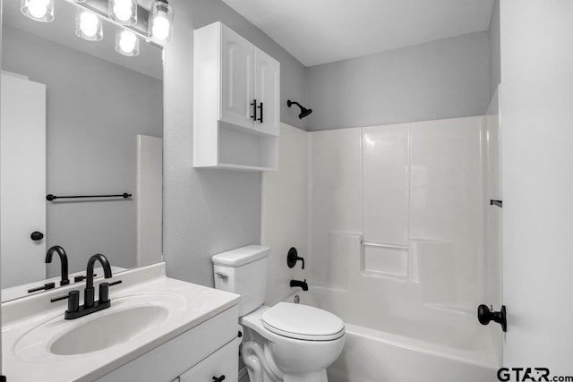 bathroom with washtub / shower combination, vanity, and toilet