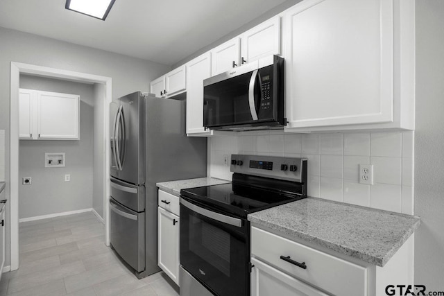 kitchen with baseboards, appliances with stainless steel finishes, light stone countertops, white cabinetry, and backsplash