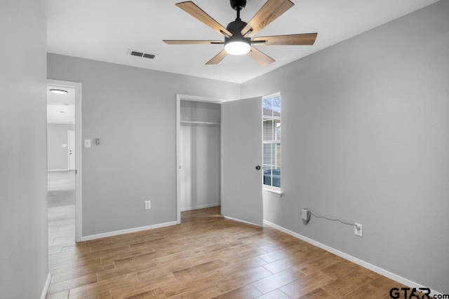 unfurnished bedroom featuring a closet, baseboards, visible vents, and light wood finished floors