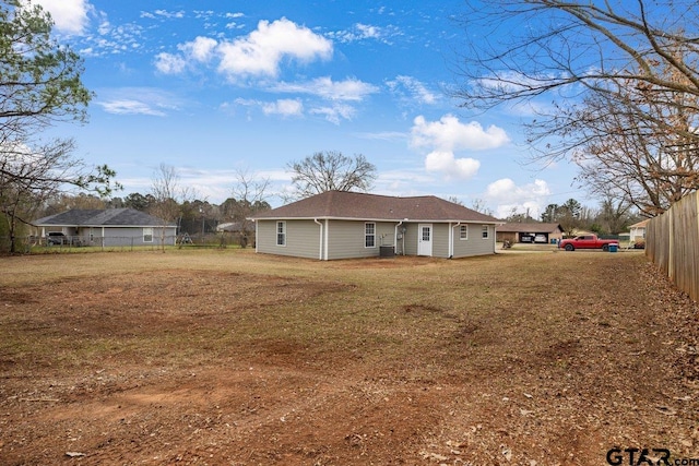 rear view of property with a yard and fence