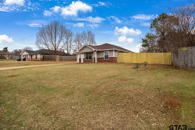 view of front of home with fence, a front lawn, and brick siding