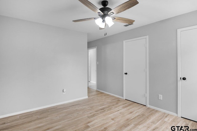 unfurnished bedroom with light wood-style floors, visible vents, baseboards, and a ceiling fan