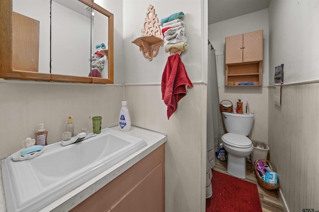 bathroom featuring wood-type flooring, vanity, and toilet