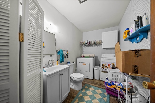 bathroom with toilet, hardwood / wood-style flooring, separate washer and dryer, and vanity