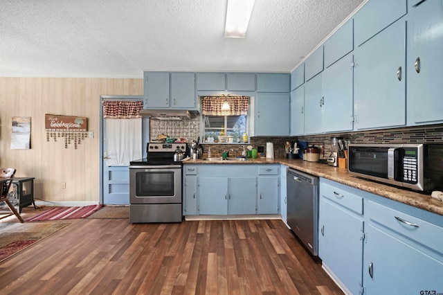 kitchen with a textured ceiling, stainless steel appliances, dark hardwood / wood-style flooring, blue cabinetry, and sink