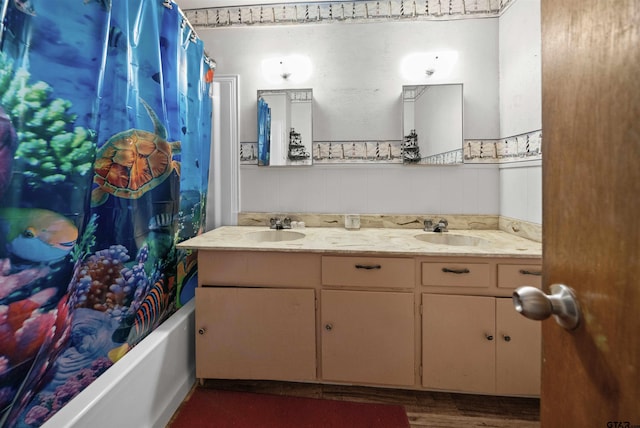 bathroom with hardwood / wood-style flooring, shower / bath combo, and vanity