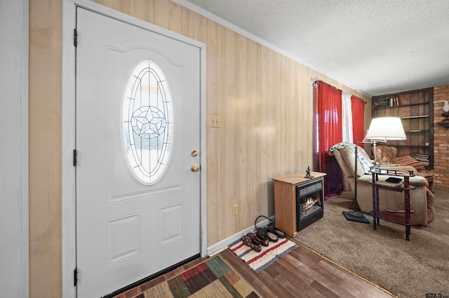 foyer featuring a textured ceiling, wood walls, and hardwood / wood-style flooring