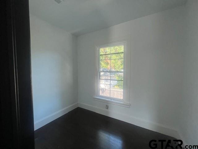 spare room with dark wood-style floors and baseboards