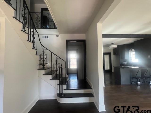 stairs featuring visible vents, baseboards, and wood finished floors