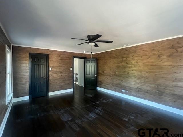 interior space with dark wood-style flooring, ceiling fan, and baseboards