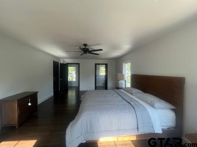 bedroom with baseboards, dark wood finished floors, and a ceiling fan