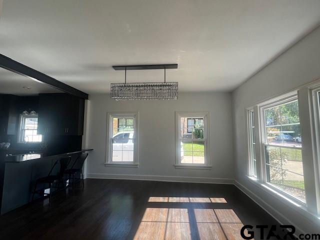 dining space featuring dark wood-style floors and baseboards