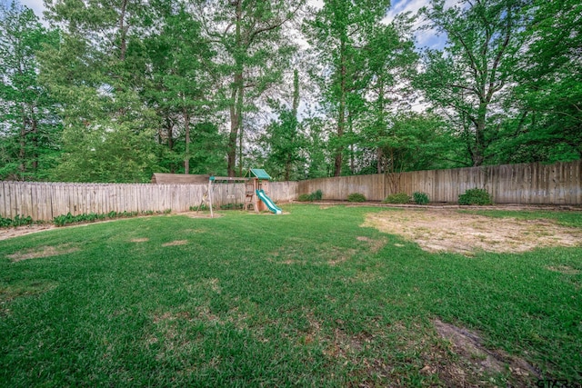 view of yard featuring a fenced backyard and a playground