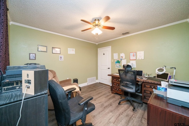 home office featuring wood finished floors, visible vents, a ceiling fan, and ornamental molding
