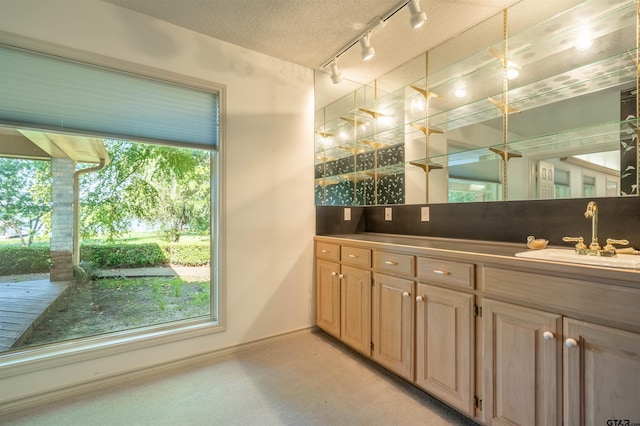 bathroom featuring track lighting, vanity, and a textured ceiling