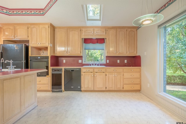 kitchen with light brown cabinets, sink, and black appliances