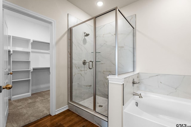 bathroom with wood-type flooring and separate shower and tub