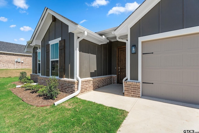 property entrance with a garage and a lawn