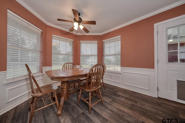 dining space featuring ceiling fan, dark wood-type flooring, wainscoting, and crown molding