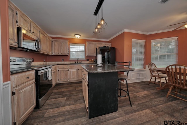 kitchen with dark wood-type flooring, a breakfast bar, a sink, appliances with stainless steel finishes, and a center island